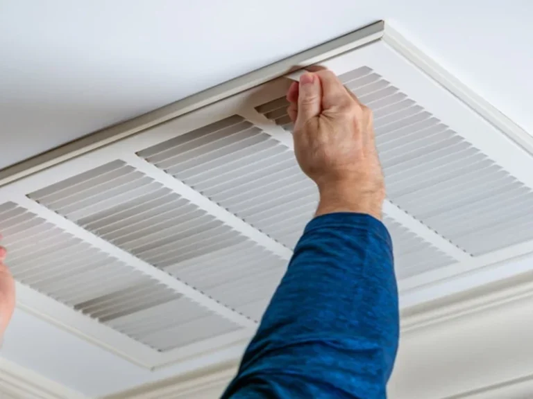 Technician cleaning an air conditioner